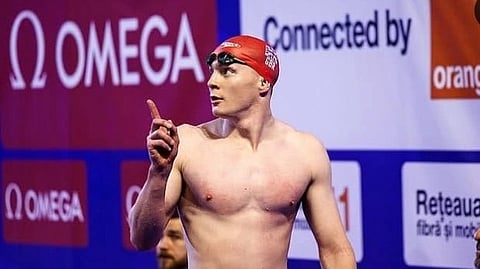 Archie in a swim cap and swim glasses on his head.