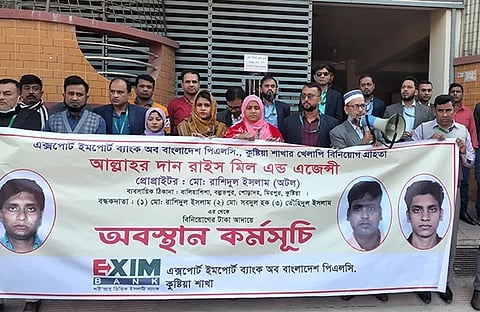 ঋণ গ্রহীতা দুই ব্যবসায়ীর বাড়ি ও ব্যবসা প্রতিষ্ঠানের সামনে অবস্থান নেন এক্সিম ব্যাংকের কর্মকর্তা-কর্মচারারী। তাদের হাতে ছিল ঋণ গ্রহীতার ছবিযুক্ত ব্যানার।