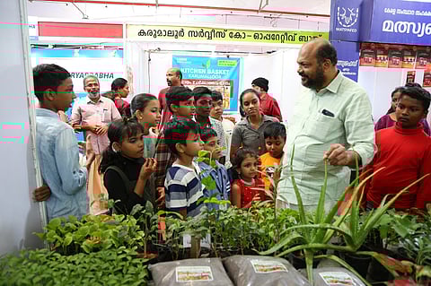 കളമശ്ശേരി കാർഷികോത്സവം സെമിനാറിൽ പങ്കെടുത്ത കുട്ടി കർഷകരോടൊപ്പം മന്ത്രി പി. രാജീവ് സ്റ്റാളുകൾ സന്ദർശിക്കുന്നു.