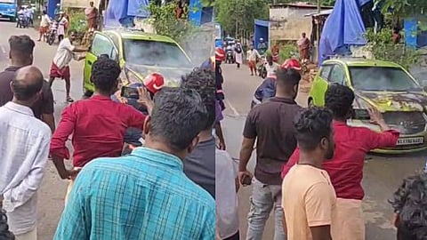 കാറിന്റെ തീയണയ്ക്കാൻ ശ്രമിക്കുന്നു