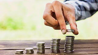Coins on scale stack on table, symbolic image for fixed deposit