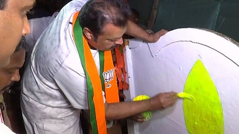 മതിലിൽ താമര ചിഹ്നം വരയ്ക്കുന്ന സുരേഷ് ഗോപി