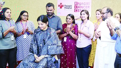 കാൻസർ രോഗികൾക്ക് വിഗ്ഗ് നിർമിക്കാനായി മുടി ദാനം ചെയ്യുന്ന നടി ശിവദ. രാജഗിരി ആശുപത്രി അഡ്മിനിസ്ട്രേഷൻ ഡയറക്ടർ ഫാ. ജോയ് കിളിക്കുന്നേൽ സമീപം.