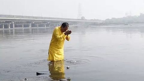 delhi bjp chief takes dip in yamuna river complains of skin rashes