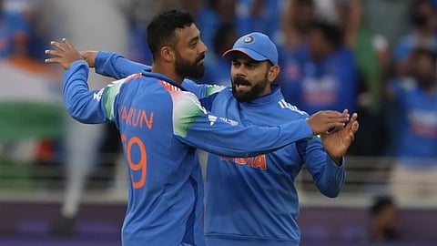 Varun Chakravbarthy celebrates a New Zealand wicket with Virat Kohli