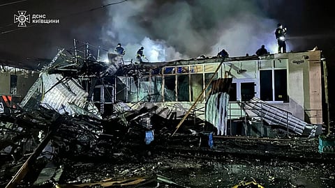 Firefighters try to put out a fire in a building following a strike in Brovary, Kyiv region, October 10, 2025