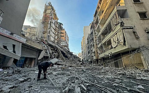 A man examines the remains of destroyed buildings at the site of an Israeli airstrike targeting Hezbollah in the Haret Hreik neighborhood in Beirut's southern suburbs on March 7, 2026