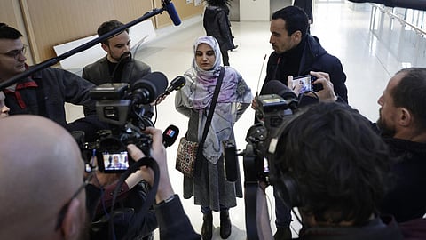 Mahdieh Esfandiari, flanked by her lawyers, speaks to the press before her trial at a Paris courthouse, 13 January 2026.