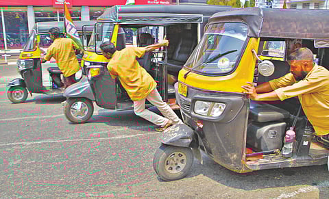 Auto rickshaw drivers pulling their vehicles towards the Secretariat in Thiruvananthapuram on Monday
									-