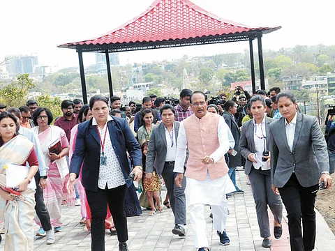 Chief Minister Shivraj Singh Chouhan is surrounded by women security personnel as a mark on the eve of Women's Day celebration, in Bhopal on Tuesday.