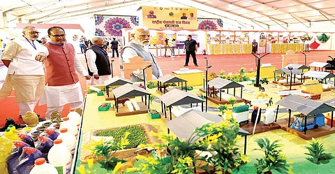 Prime Minister Narendra Modi goes through an exhibition during the National Panchayati Raj Divas programme in Rewa on Monday. Governor Mangubaho Patel, Chief Minister Shivraj Singh Chouhan
