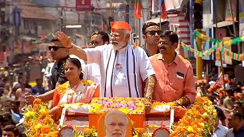 Prime Minister Narendra Modi waves to supporters during a roadshow, ahead of the upcoming Lok Sabha election, in Palakkad, Tuesday, March 19, 2024.
