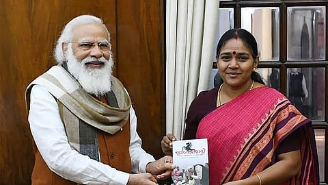Shobha Surendran presents her book on Prime Minister Narendra Modi to him.