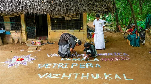 People prepare a kolam, a floor drawing made from coloured powder, that translates to "Greeting America, Our Wishes For Kamala Harris Victory" ahead of the US presidential election, at her ancestral village, Thulasendrapuram, in Thiruvarur district, Tuesday, Nov. 5, 2024.