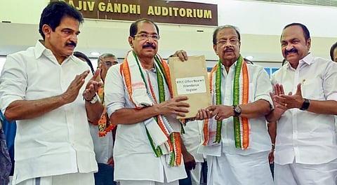 Former Kerala Pradesh Congress Committee (KPCC) president K Sudhakaran hands over a register to newly elected KPCC President Sunny Joseph.