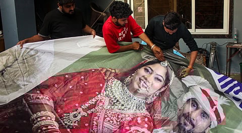 Family members of Raja Raghuvanshi, who was allegedly murdered during his honeymoon in Meghalaya, cut out the picture of his wife Sonam Raghuvanshi from a poster of their marriage after she was accused of plotting his murder, in Indore, Tuesday, June 10, 2025.