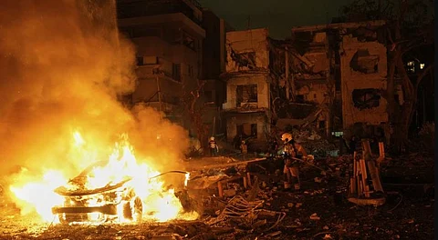 Firefighters work to extinguish a blaze after a missile launched from Iran struck Tel Aviv, Israel, Monday, June 16, 2025.