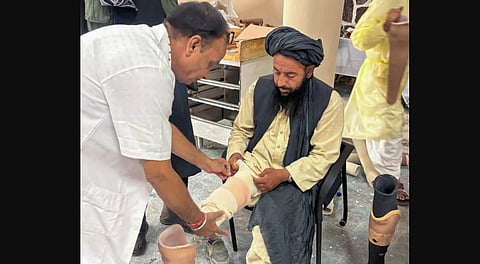 On June 29, 2025, a volunteer of Bhagwan Mahaveer Viklang Sahayata Samiti (BMVSS), Jaipur, provides a prosthetic leg to an amputee during a five-day Jaipur Foot camp organised as part of India's ongoing humanitarian assistance to the people of Afghanistan, in Kabul.