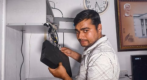 A police officer seizes a surveillance hard disk from Fakir Mohan (Autonomous) College during an investigation after a female student allegedly set herself on fire over sexual harassment, in Balasore district, Odisha, Saturday, July 12, 2025.