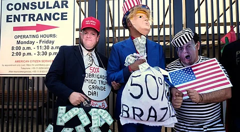 Demonstrators wearing masks in the likeness of, from left, Sao Paulo's Governor Tarcisio de Freitas, U.S. President Donald Trump and Brazil's former President Jair Bolsonaro protest the 50% U.S. tariff on Brazilian goods outside the U.S. consulate in Sao Paulo, Friday, Aug. 1, 2025.