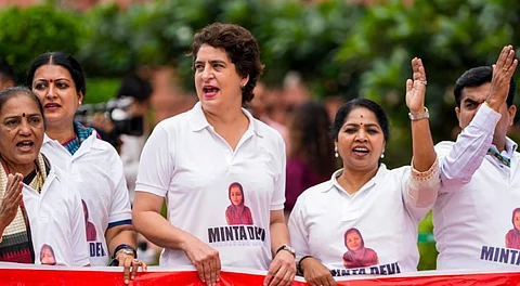 Congress MP Priyanka Gandhi Vadra and other INDIA bloc members seen wearing T-shirts featuring the name Minta Devi, a voter allegedly listed as 124 years old in the Election Commission's voter list, during their protest over the issues of 'poll fraud' and Special Intensive Revision of electoral rolls, at the Monsoon session of Parliament, in New Delhi, Tuesday, Aug. 12, 2025.