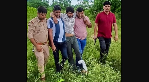 Police personnel apprehend a man, accused of setting his wife on fire over dowry, after he was shot in leg while escaping custody, Sunday, Aug. 24, 2025.