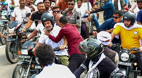 Rahul Gandhi being hugged by a supporter as the former rides a motorcycle during the 'Voter Adhikar Yatra', in Bihar.