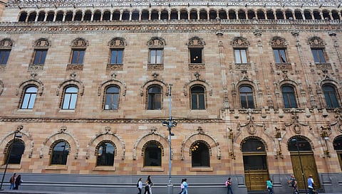 Pedestrians walk past the Main Post Office in Mexico City