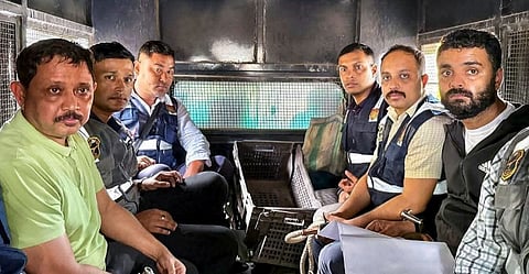 North East India Festival (NEIF) chief organiser Shyamkanu Mahanta and his manager Siddhartha Sharma, alleged to be involved in the death of legendary singer Zubin Garg in Singapore, are brought to the CID office inside a police vehicle following their arrest from Delhi, in Guwahti, Assam, Wednesday, Oct. 1, 2025.