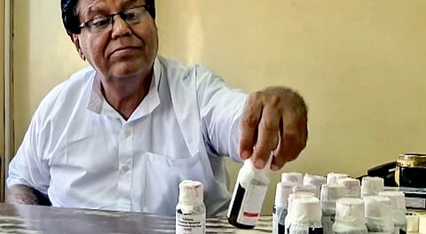 An official looks at bottles of the �Coldrif� cough syrup after a raid by the Drug and Pharmaceuticals Department officials at Kataria Pharmaceuticals, after the deaths of 11 children.