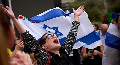 People react as they celebrate following the announcement that Israel and Hamas have agreed to the first phase of a peace plan to pause the fighting, at a plaza known as hostages square in Tel Aviv, Israel on Oct. 9.