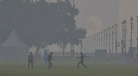 Children play football near India Gate as smog engulfs the area, with the Air Quality Index (AQI) remaining in the 'very poor' category, in New Delhi, Sunday, Nov. 2, 2025.
