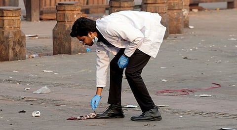 A forensic official collects samples from the site in the aftermath of the blast that occurred near Red Fort Metro Station on Monday
