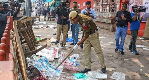 A police official searches for evidence in the aftermath of a car blast near Red Fort, in New Delhi, Thursday, Nov. 13, 2025.