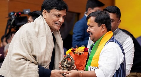 Minister of State for Home Affairs Nityanand Rai, left, congratulates newly-appointed BJP National Working President Nitin Nabin as he takes charge during a ceremony, at the party headquarters in New Delhi, Monday, Dec. 15, 2025.