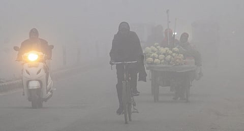 Commuters navigate through dense fog on a cold morning, in Dehradun, Wednesday, Dec. 17, 2025.