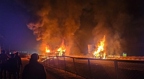 Flames and smoke billow out after a bus caught fire following a collision with a speeding truck, in Chitradurga, early Thursday, Dec. 25, 2025.