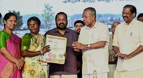 Kerala Chief Minister Pinarayi Vijayan distributes a title deed to a family during the allotment of houses to 178 families in the first phase of the Wayanad Model Township for landslide survivors at Elston Estate, in Kalpetta, Kerala, Sunday, Mar. 1, 2026.