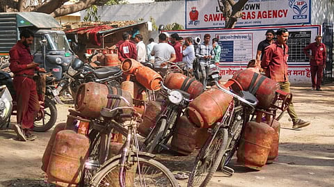 LPG cylinder delivery personnel prepare for distribution outside a gas agency in New Delhi, Wednesday, March 11, 2026.