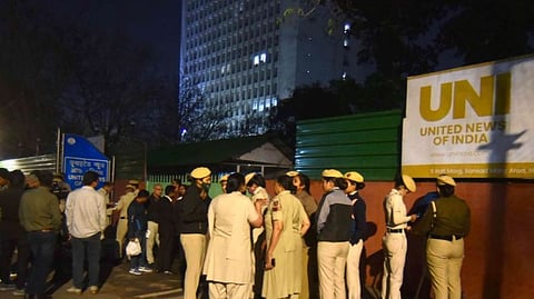 UNI staff members gather outside their office following a forcible eviction from the premises in New Delhi on Friday.