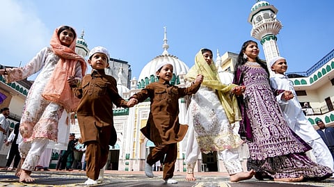 Children pose for photographs with a cat on the occassion of Eid al-Fitr, at Jama Masjid in Nagpur, Maharashtra, Saturday, March 21, 2026.