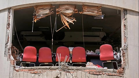 A row of chairs is seen through a hole left by U.S.-Israeli airstrikes Friday at Shahid Beheshti University in Tehran, Iran, Saturday, April 4, 2026.
