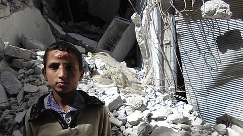 Un niño delante de un edificio destruido en Aleppo, en Siria (Foto: OCHA/Gemma Connell)