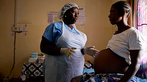 Una comadrona examina a una mujer embarazada en Sierra Leona (Foto: UNICEF/Kate Holt)