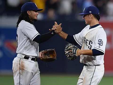 El experimentado venezolano Freddy Galviz felicita a su compañero en la llave de las doble matanzas, el mexicano Luis Urías, al final de su partido de debut en las Grandes Ligas (Foto cortesía @Padres)