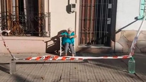 Abuelita cerca su banqueta para tomar el sol en cuarentena