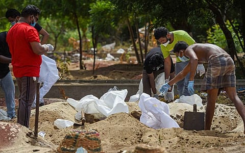 जून 2020 में चेन्नई के एक कब्रगाह में कोविड-19 के चलते जान गंवाने वाले शख्स का अंतिम संस्कार करते वॉलंटियर्स. (फोटो: पीटीआई)