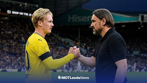 Julian Brandt shakes the hand of Daniel Farke, with Elland Road in the background