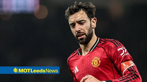 Bruno Fernandes running in action for Manchester United looking left and down
