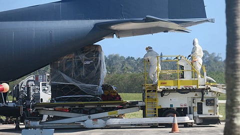 Personnel wearing personal protection equipment (PPE), and a load of humanitarian relief supplies sent by New Zealand are seen next to an aircraft at Fua?amotu International Airport on the island of Tongatapu, Tonga, January 20, 2022 in this picture obtained from social media.